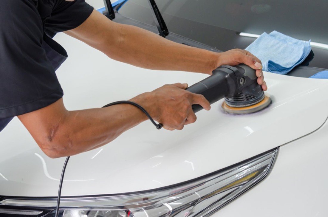 Fahrzeugaufbereitung: Motorhaube wird mit der Poliermaschine bearbeitet